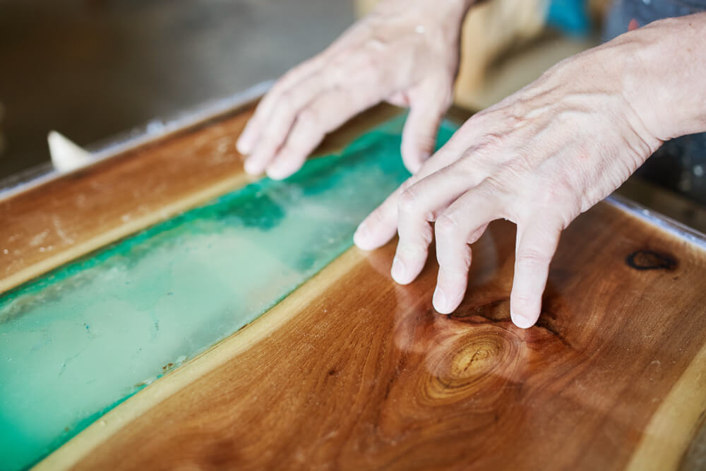 carpenter working on epoxy river table carpenter working on epoxy river table